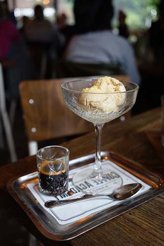 cream ice cream beside stainless steel spoon creme